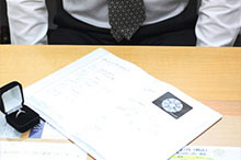 机の上に鑑定中のダイヤと鑑定書